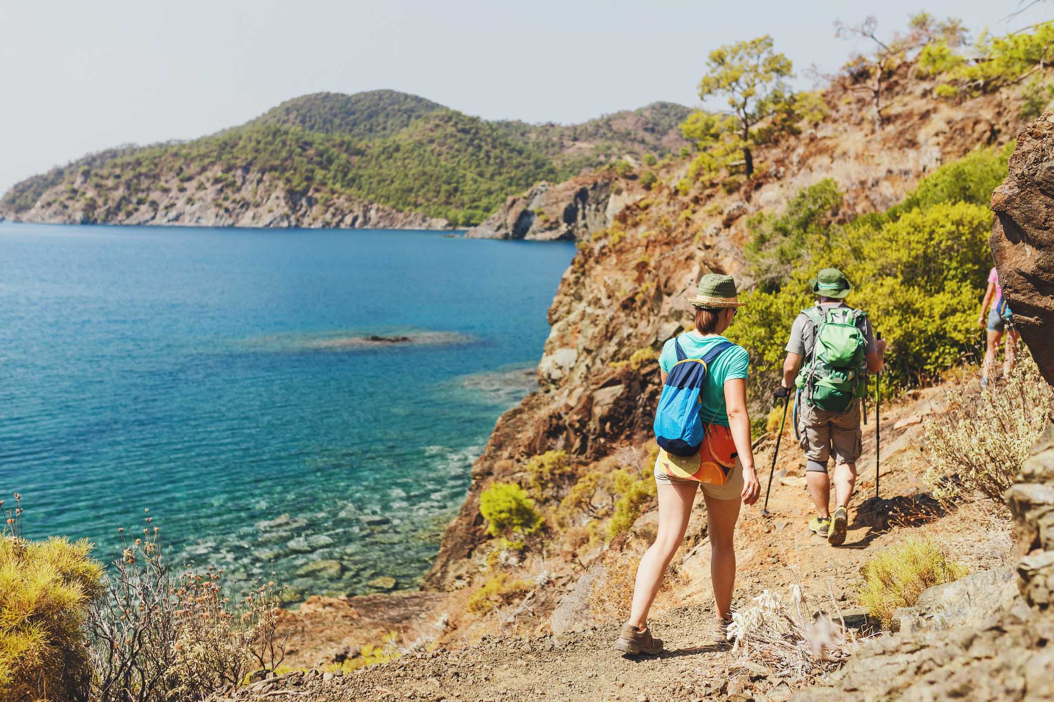 Group of Hikers walking by Lycian Way trail along wild beach and mountains in Turkey